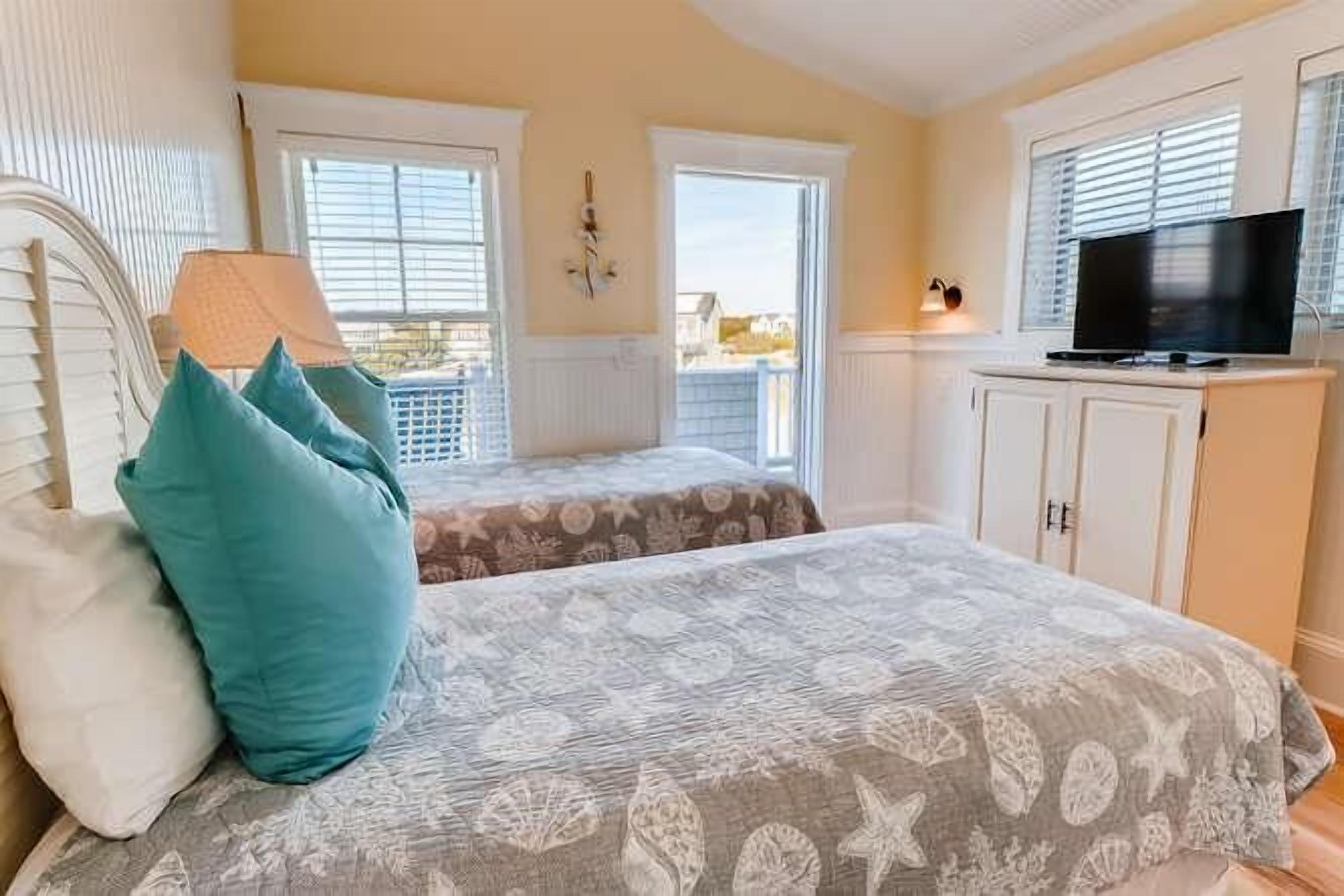 Un dormitorio con cama, televisión y ventana.
