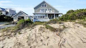 A beachfront house with a large porch and a garage.