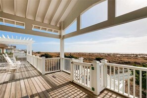 A wooden deck with white railings and a pergola, overlooking a beach. - Oceanfront, separate detached suite with rental of home, BHI (Bald Head Island)