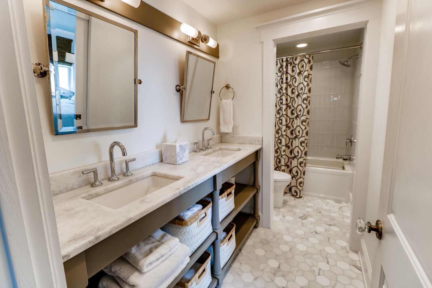 Un baño con dos lavamanos, inodoro y ducha.