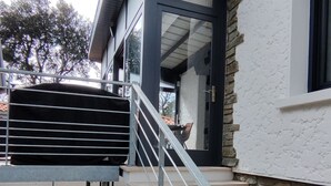 A modern house with a stone exterior, a metal staircase, and a large air conditioning unit. - Beautiful apartment for up to 6 people, south-facing terrace, beach on foot! (La Tremblade)