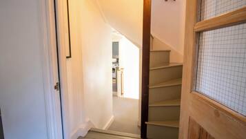 A staircase leading to a second-floor area with a kitchen visible in the background.