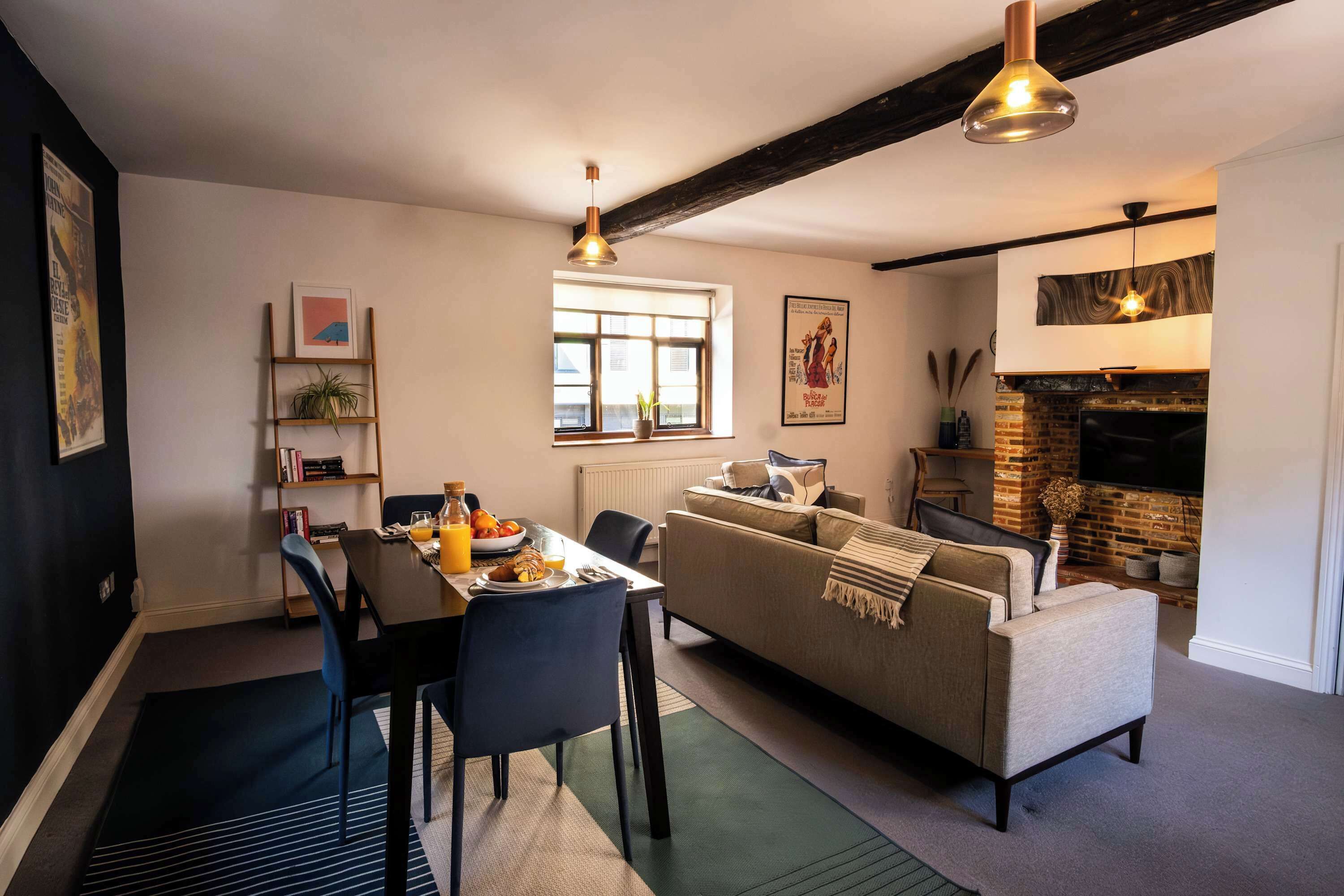 Uma sala de estar moderna com área de jantar, lareira e uma janela ampla.