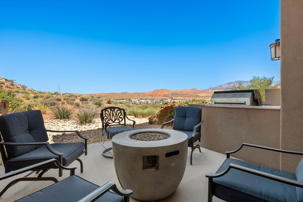 An outdoor patio with a fire pit, seating, and a view of a desert landscape. - Views Over Coral Canyon, PING PONG, GAMING SYSTEMS, 2 Community Pools (Washington)