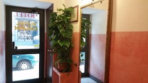 A hotel entrance with a door displaying a sign for a hotel and a parking garage. - Hotel Chopin (Milan)