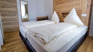 A bedroom with a large bed, wooden headboard, and a wooden floor. - Vacation apartment Landglück Seegraben (Bechhofen)