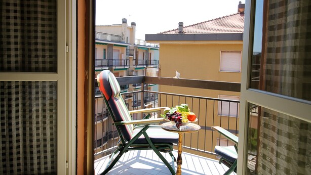 A balcony with a chair and a small table with fruit. - House Adelin (Andora)