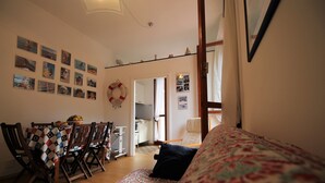Un salon chaleureux comprenant un coin repas, un canapé à motifs et un mur décoré de photographies.