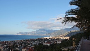 A coastal cityscape with a view of the sea and mountains in the background. - House Orsa Maggiore (Bordighera)