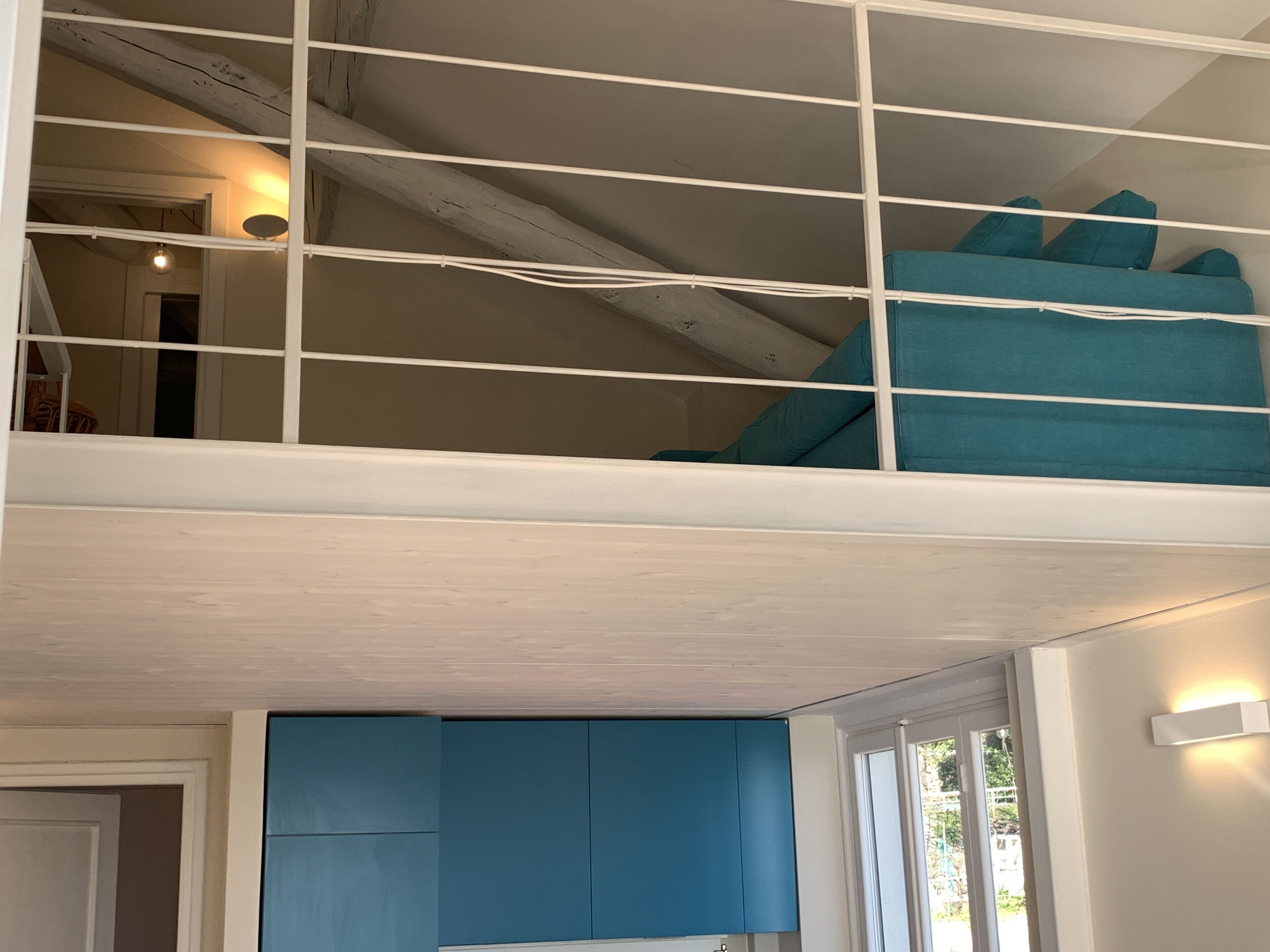 A room with a bunk bed, a window, and a door.