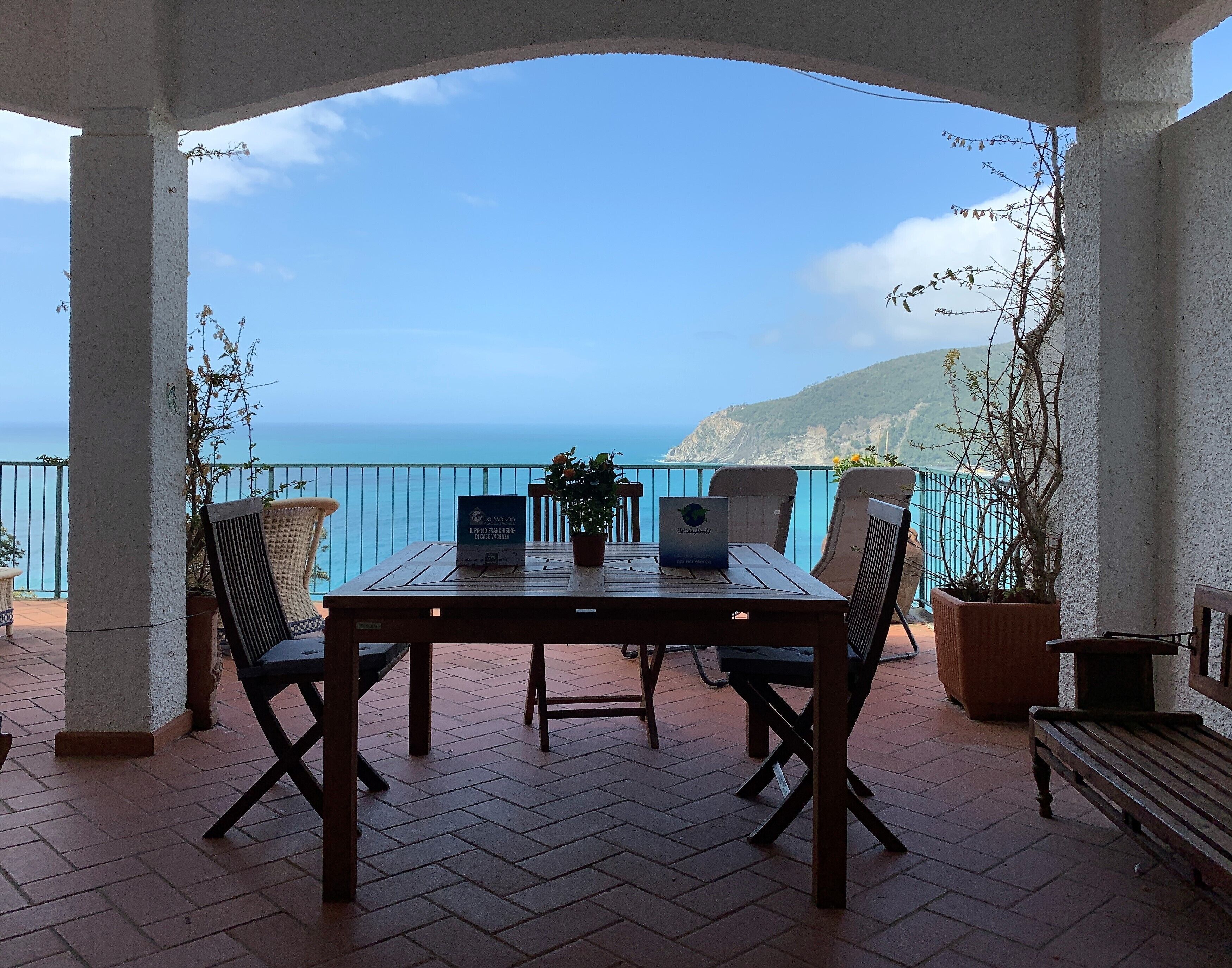 Una terraza con mesa y sillas, con vista al mar.