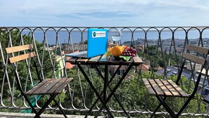 A balcony with a laptop, a glass of water, and a fruit bowl. - House Blue Sky (Genoa)