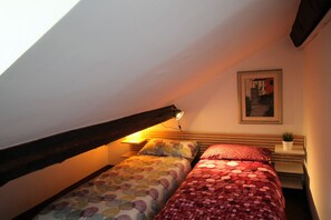 A bedroom with two beds, a nightstand, a wall-mounted shelf, and a painting. - ILA1505 House Golia (Genoa)