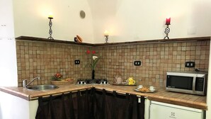A kitchen with a tiled backsplash, a gas stove, a microwave, and a sink. - House Cornelia (Pietra Ligure)