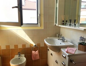 Ein Badezimmer mit Waschbecken, Bidet und Fenster.