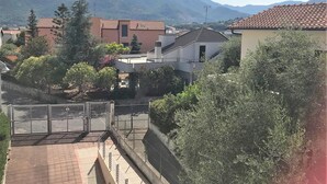 Ett bostadsområde med hus, en grind och berg i bakgrunden.