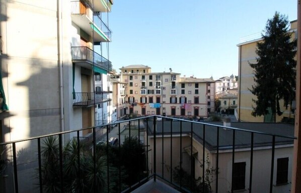 A residential area with multi-story buildings, balconies, and a clear sky.