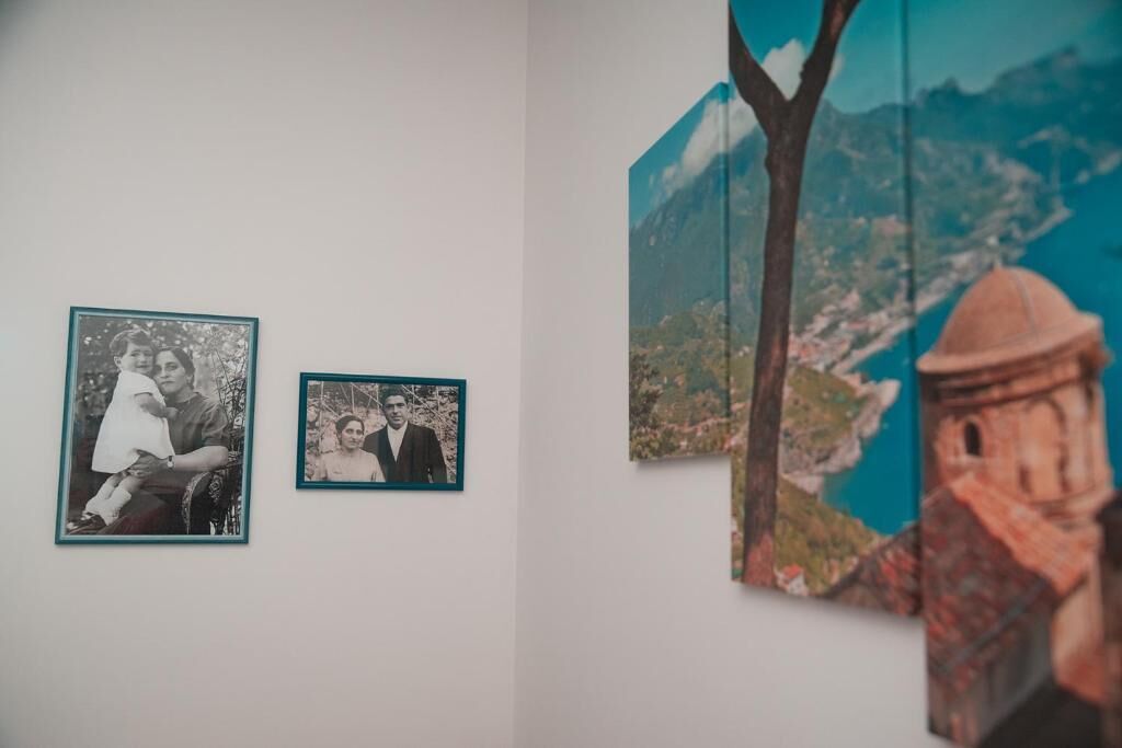 Una pared con dos fotografías enmarcadas y un cuadro grande.