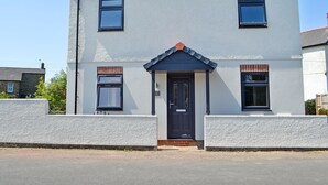 A two-story house with a dark-colored front door, a small porch, and a tiled roof. - Great property for exploring the Forest of Dean and surrounding areas. (Mile End, near Coleford)