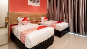 A hotel room with two beds, a wooden headboard, a red wall, a large window with curtains, and a framed picture on the wall. - OYO 3159 Festive Inn (Medan)
