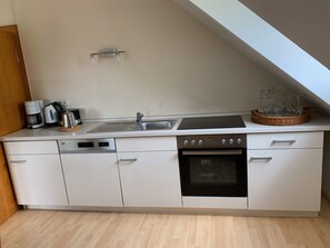 Een koelkast, een magnetron, een kookplaat, een vaatwasser