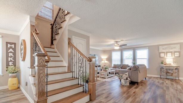 A spacious living room with a wooden staircase, a fireplace, and a cozy seating area. - Sweet Escape Homes: 3000sf Rustic Modern Home - Center of Dallas & FW (Grand Prairie)