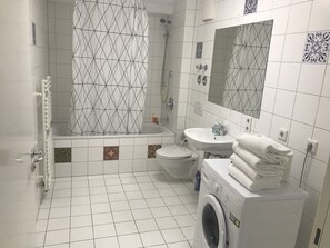 Een bad, een haardroger, vloerverwarming, handdoeken