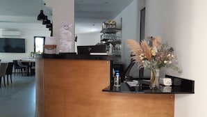Eine moderne Küche mit einer geschwungenen Holzinsel, schwarzen Pendelleuchten und einer dekorativen Vase mit Blumen.