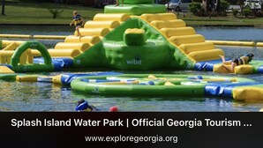 Een waterpark met opblaasbare speelconstructies en iemand op een platform.