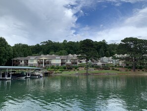 A lakeside residential area with multi-story houses, a dock with boats, and a clear sky. - This community is located in the North Georgia mountains and on Lake Chatuge. (Hiawassee)