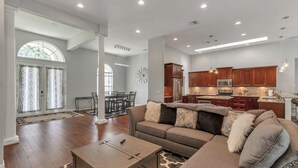 A spacious living room with a large sofa, a coffee table, and a dining area with a table and chairs. - Everything you need in a home to enjoy Florida. (Lutz)