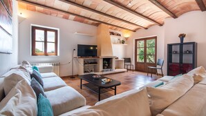 A living room with a fireplace, sofa, and television. - Holiday house with private pool, close to Sant Llorenç des Cardassar, Mallorca (Sant Llorenç Des Cardassar)