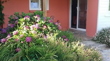 Een huis met een stenen pad dat naar een houten veranda leidt.