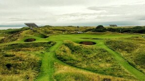 Un campo de golf con búnkeres y cielo despejado.