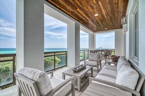 Enjoy ocean views and comfortable seating on this expansive balcony with sofa and chairs.