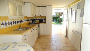 A compact kitchen with white cabinets, a yellow countertop, and a patterned tablecloth. - Villa hyper center, quiet, 4 bedrooms, 2 bathrooms, enclosed garden (200m2) WIFI (Royan)