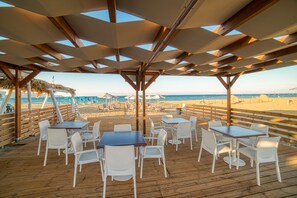 På stranden, solsenger, parasoller og strandbar