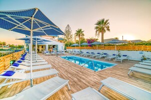 Una piscina al aire libre de temporada, sombrillas