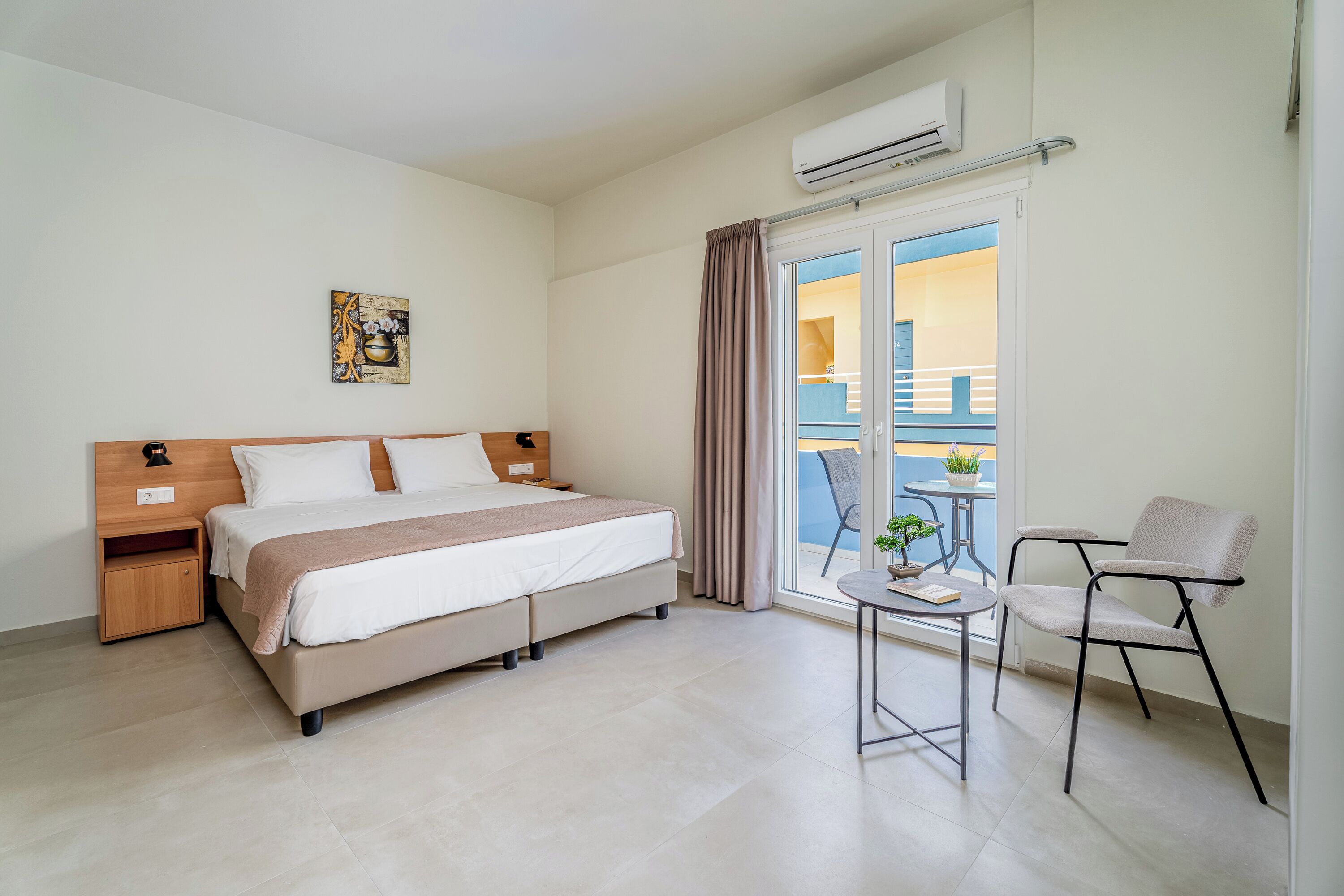 A bedroom with a bed, bedside table, and a small table with a chair.