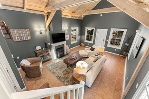 A spacious living room with a fireplace, seating area, and a television.