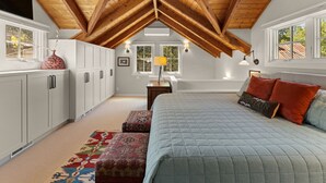 Une chambre avec un plafond de style industriel, un lit, une table de chevet et une fenêtre.