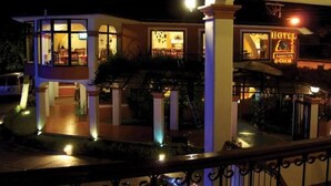 A hotel with a two-story structure, a visible staircase, and a sign indicating it offers a restaurant and coffee. - Hotel Arrecife de Coral (San Cristóbal de las Casas)