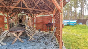 A wooden gazebo with a stone floor, a table, and benches. - 2 bedroom pet friendly home in Legbad (Legbad)