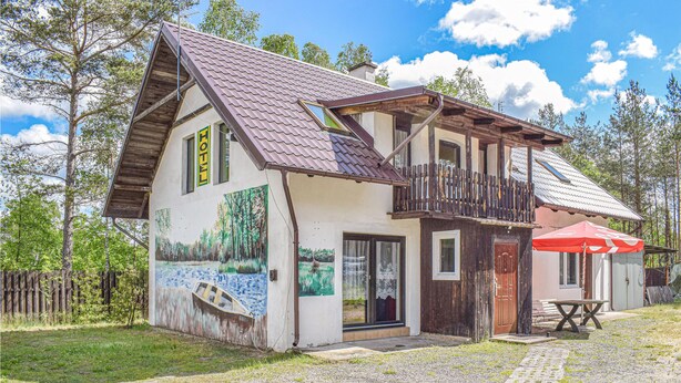 A two-story house with a sloped roof, a balcony, and a painting of a landscape on the side. - 2 bedroom pet friendly home in Legbad (Legbad)