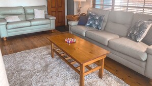 A living room with two sofas, a wooden coffee table, and a lamp. - Little Beach Bungalow - at Bartletts (Bonny Hills)