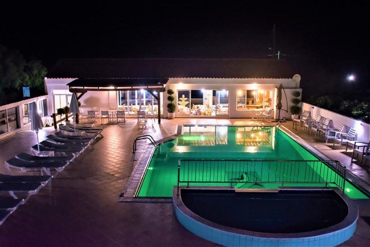 Una piscina al aire libre, sombrillas, sillones reclinables de piscina