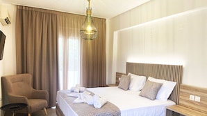 Una habitación de hotel con una cama, una silla, una mesita de noche y una lámpara colgante.