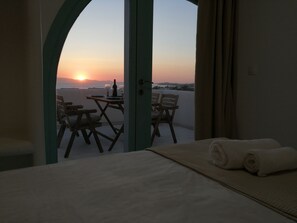 A balcony with a table set for two, overlooking a sunset. - Two floor cycladic house (Naxos)
