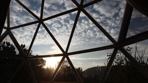 Une structure géométrique offrant une vue sur le ciel et le soleil.