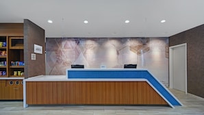 A reception desk with a blue top and wooden base, a wall with geometric patterns, and a sign that reads "BONVY". - Springhill Suites by Marriott Hartford Cromwell (Cromwell)